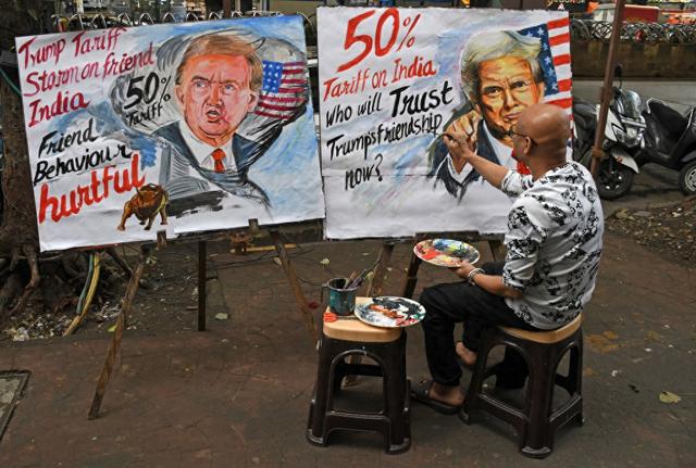 当地时间2025年8月7日，印度孟买，一名教师在其艺术学校外绘制美国总统特朗普对印度关税上调至50%的海报。视觉中国 图